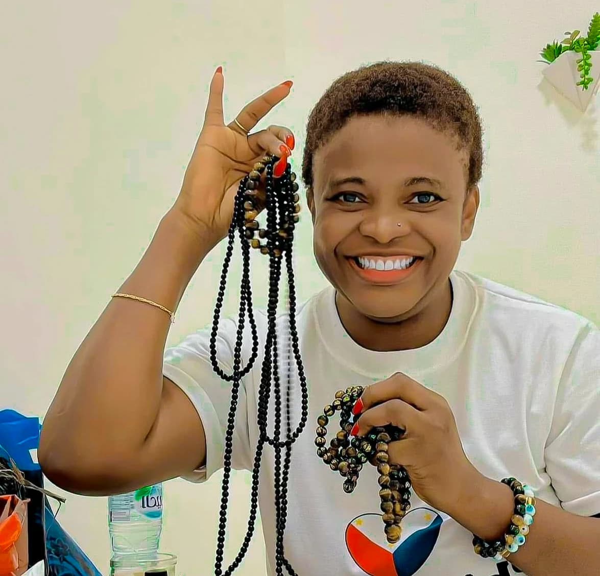 Angela Nwosu smiling, holding strands of beads